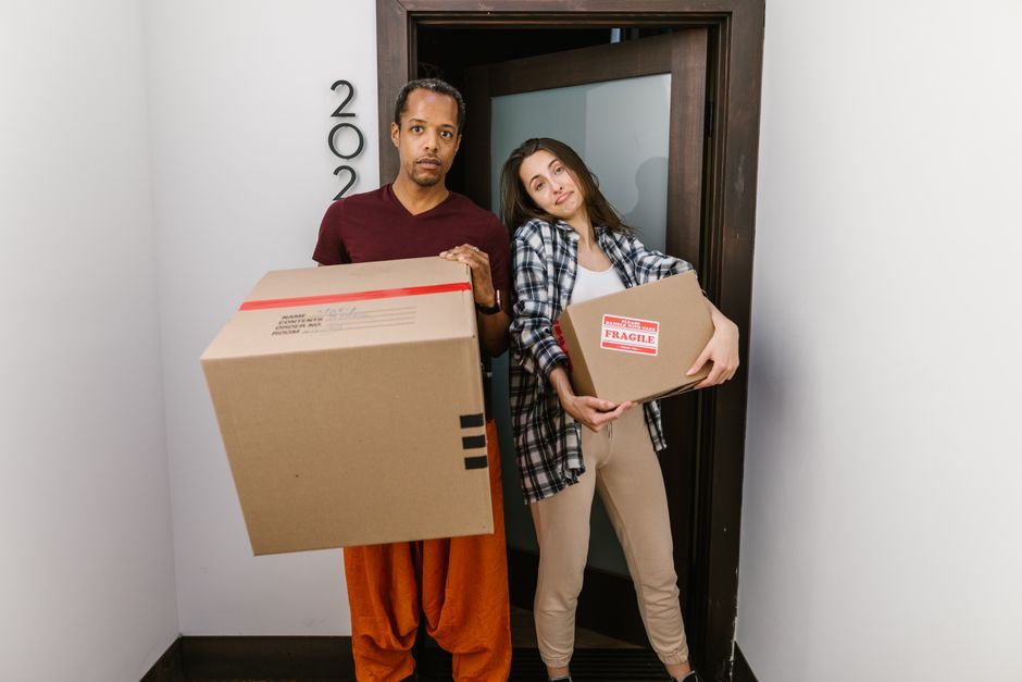 Friendly movers carefully carrying a box